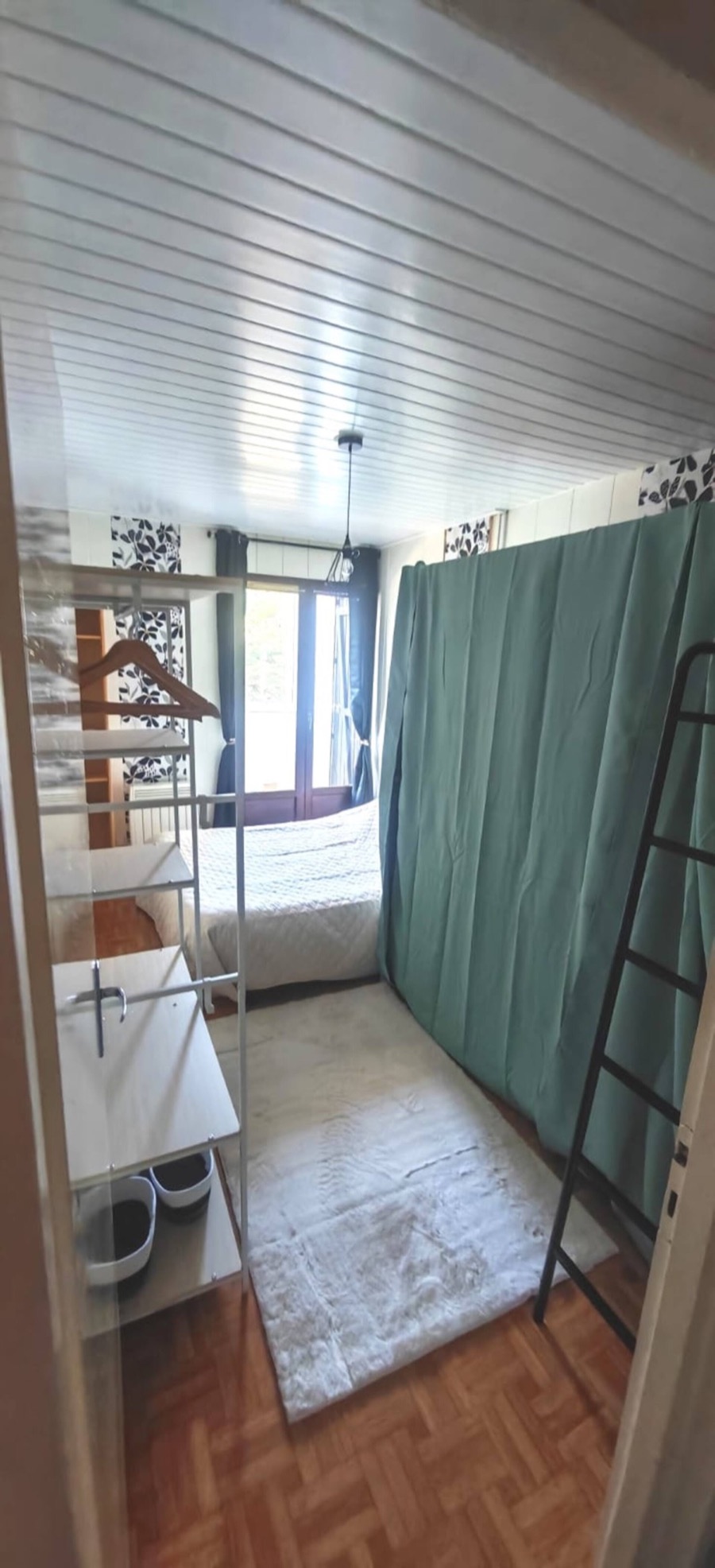 La chambre : grand lit et lits superposés derrière le rideau